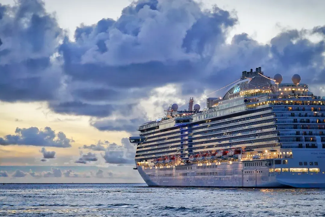 luxury cruise ship sailing through calm Caribbean waters at sunset