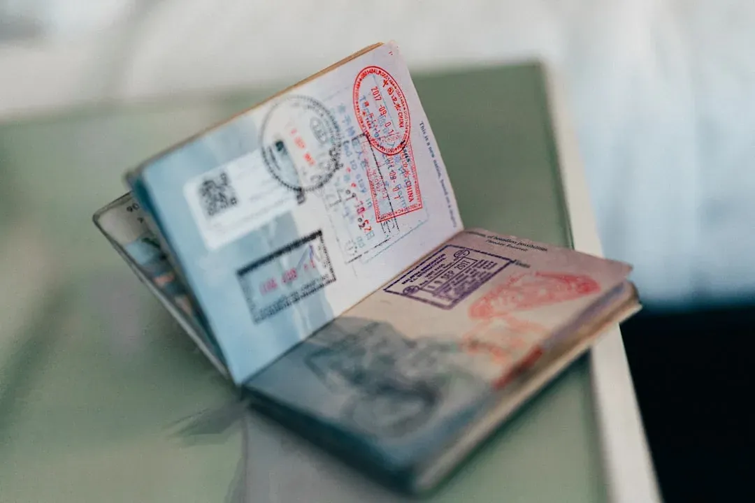 passport and travel documents laid out on a wooden table