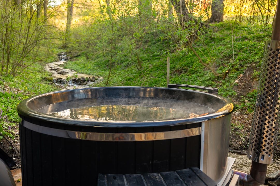 Hot tub in a camping setting with trees and mountains.